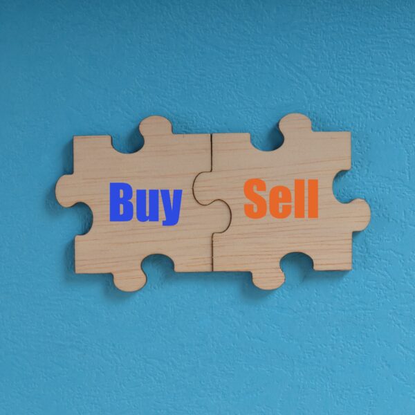 Wooden jigsaw puzzle with text BUY and SELL.